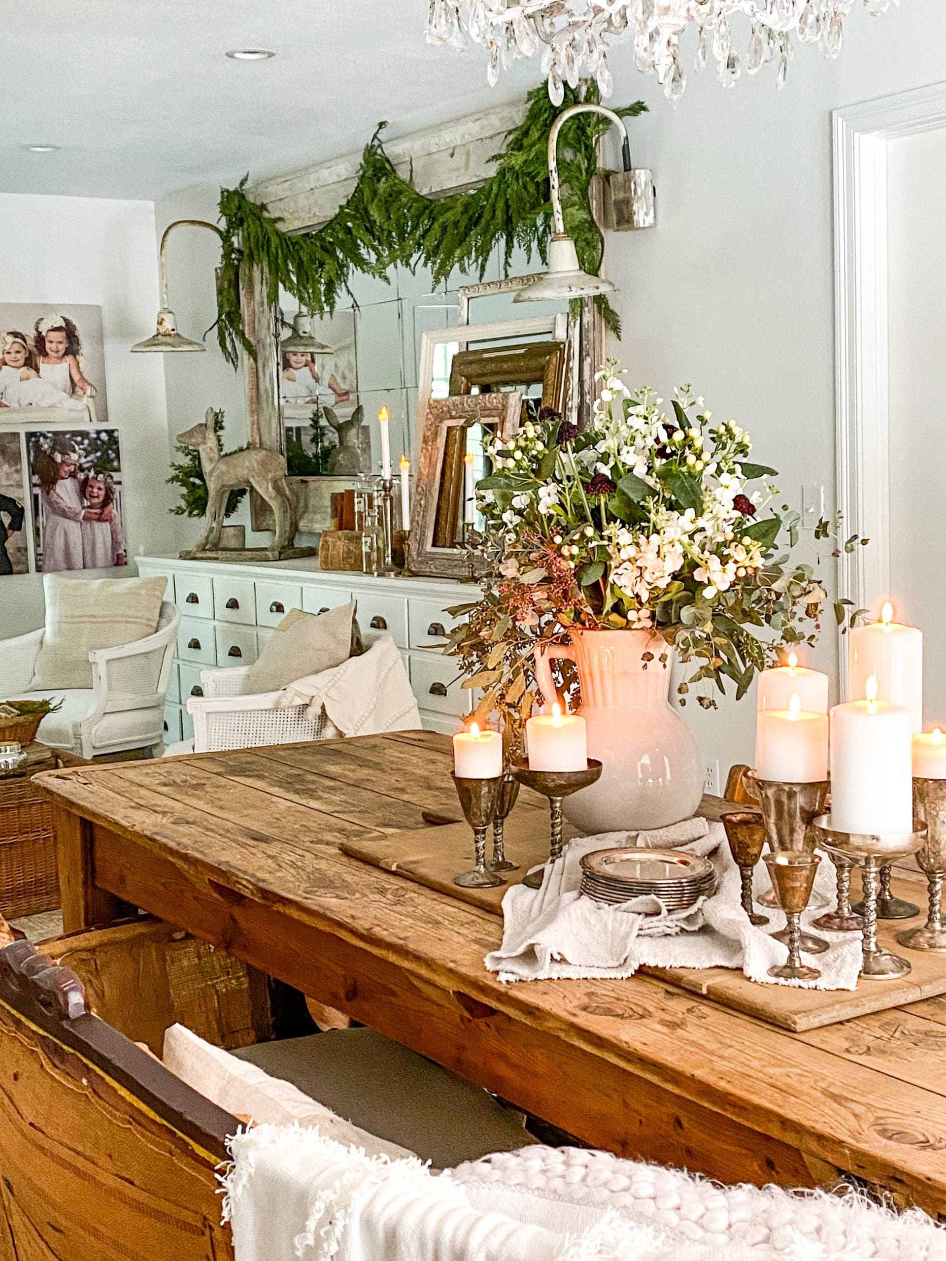 view of dining room with a beautiful white apothecary and faux greenery garlands hung across a large mirror