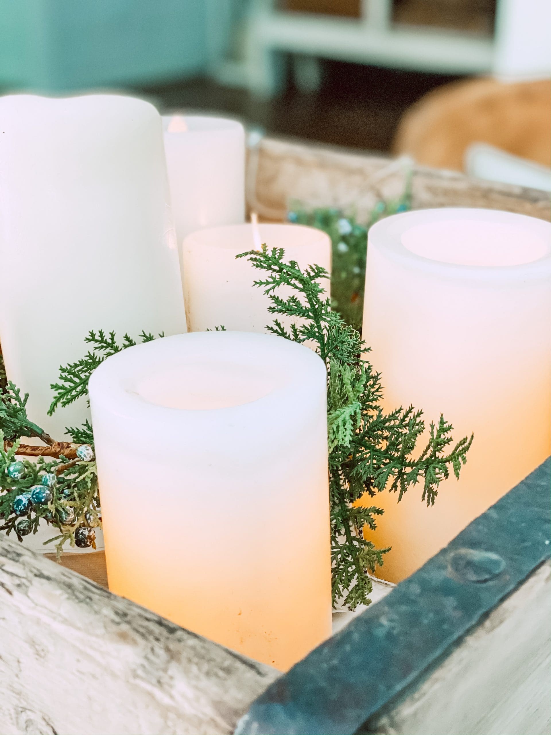 realistic battery candles and faux christmas greenery in a wooden tray