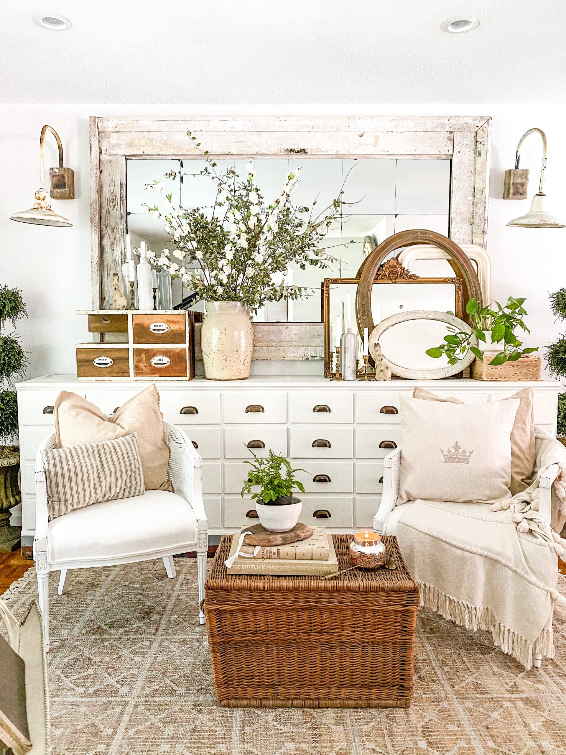 beautiful music room with white apothecary with large mirror on top, a small tree and other spring vignettes on top