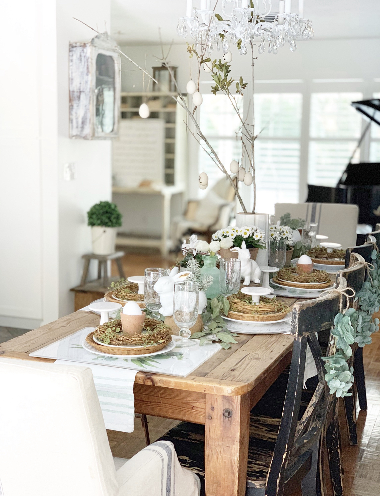 wide view of an Easter table setting with bunnies, greenery, and a beautiful table runner