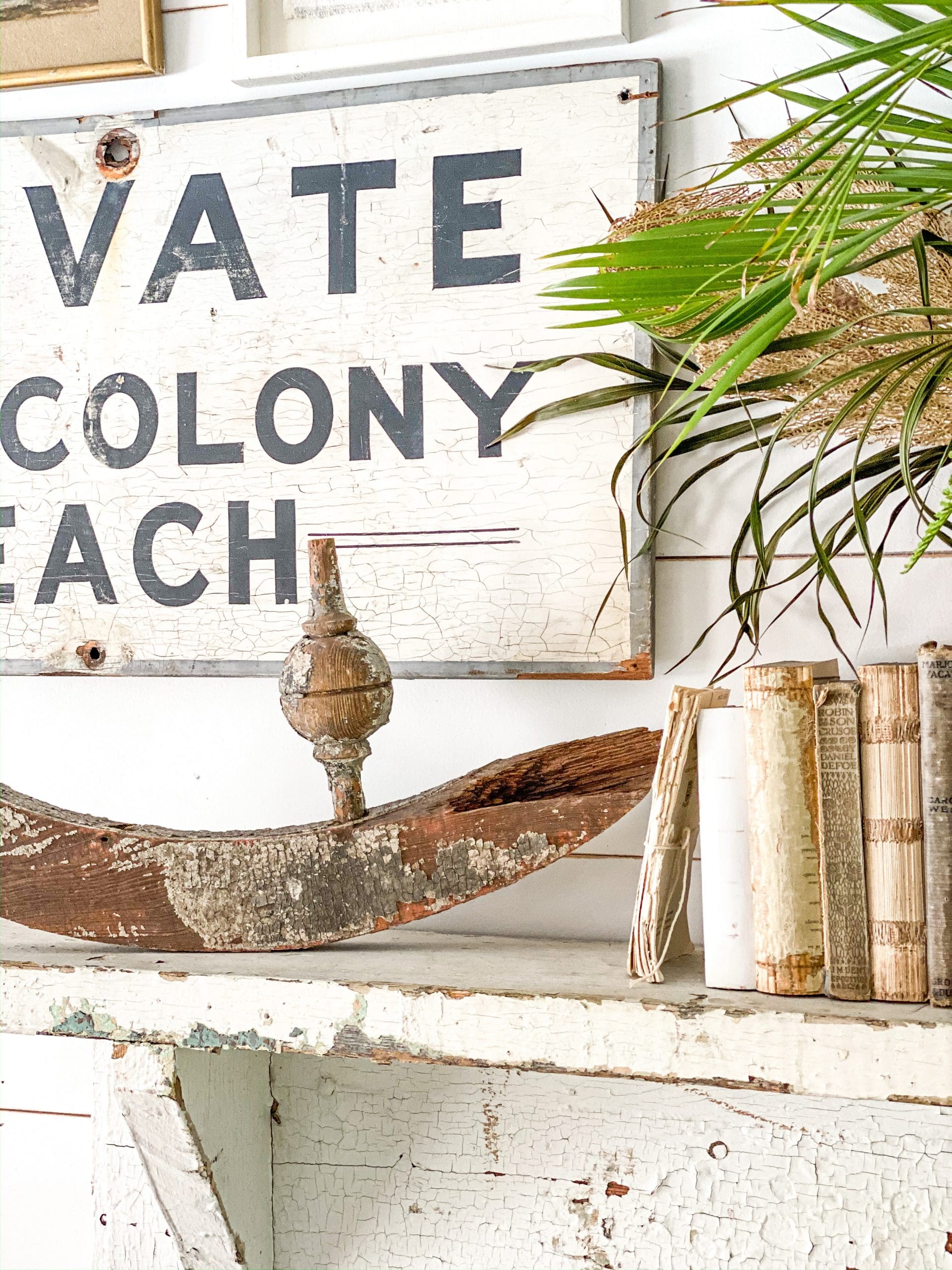 coastal architectural piece with neutral vintage books and a vintage  coastal black and white sign