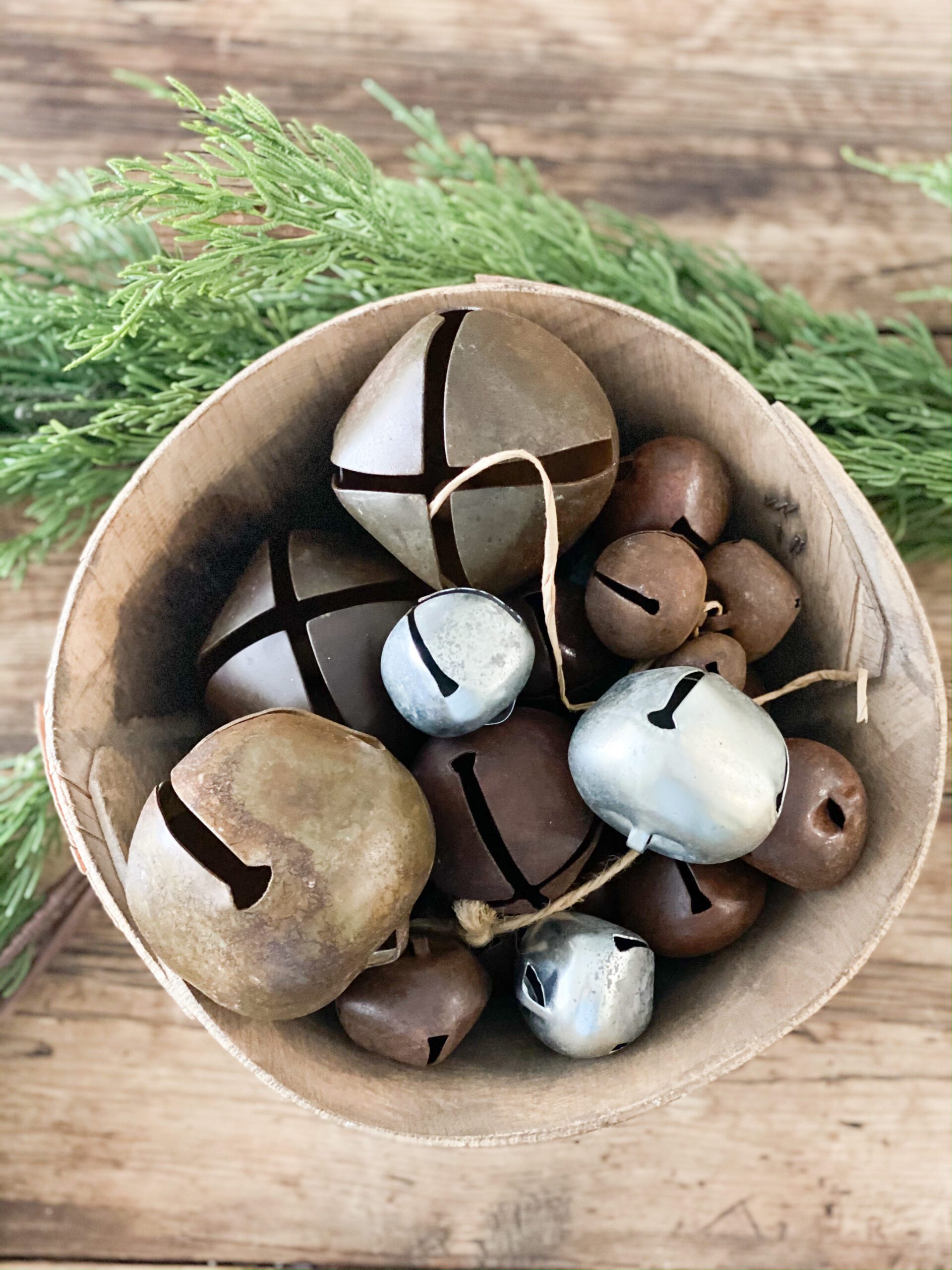 different sizes of bells in a small wooden bowl