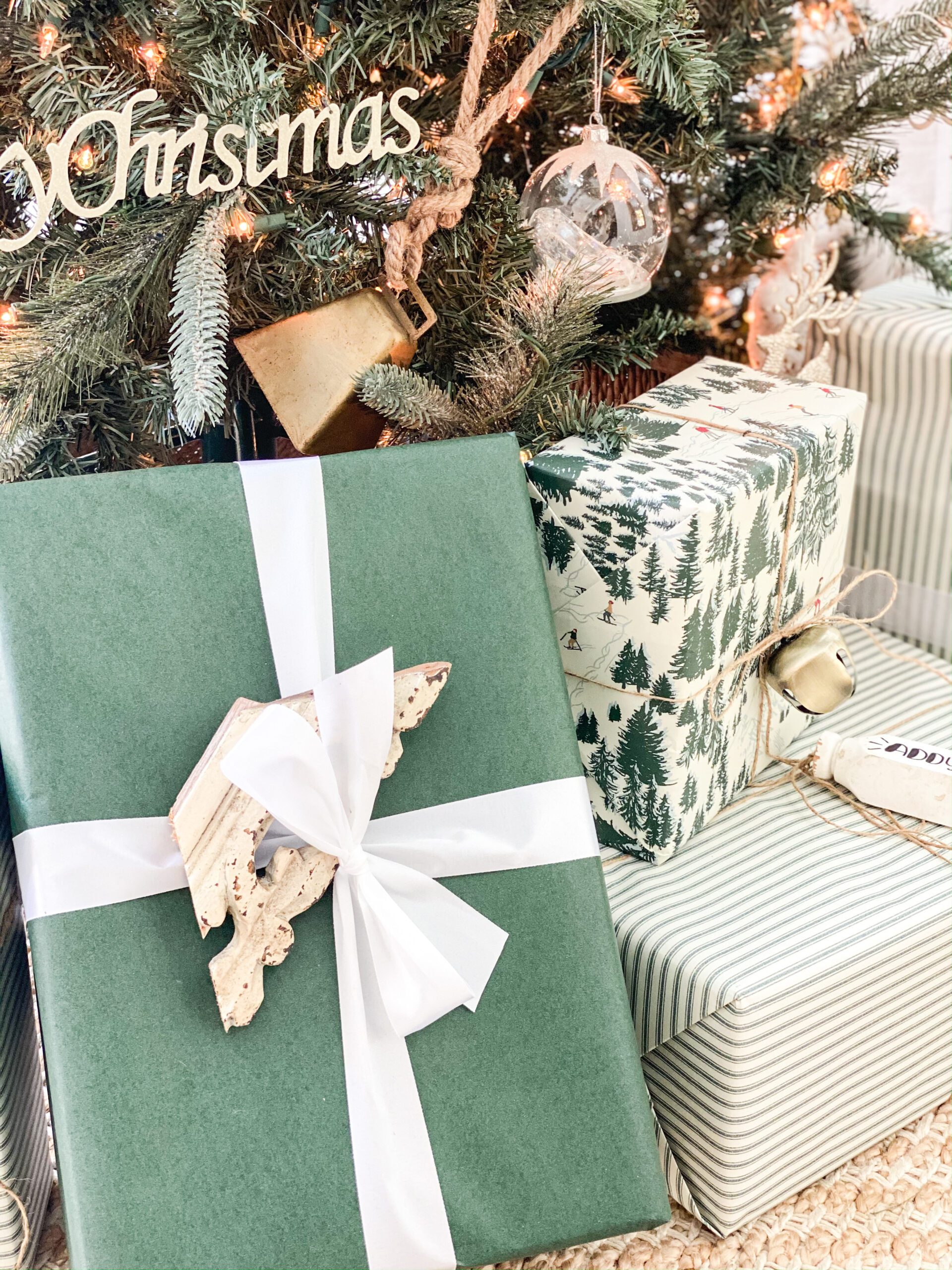 gift wrapped with green wrapping paper and a small wooden salvage piece tied onto it with white ribbon