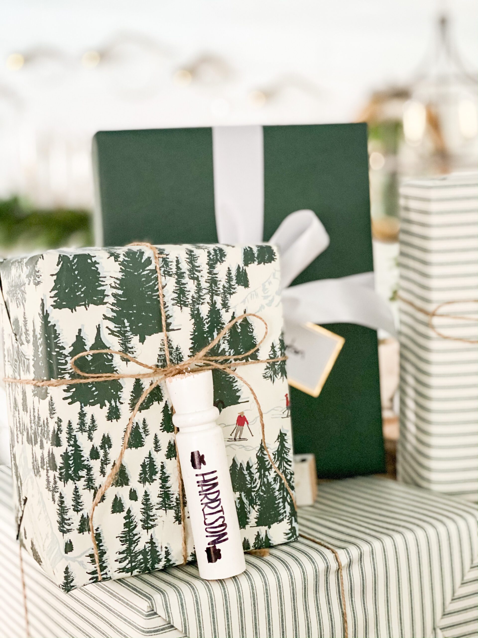 gift wrapped with Christmas tree wrapping paper with personalized wooden spindle tied around it