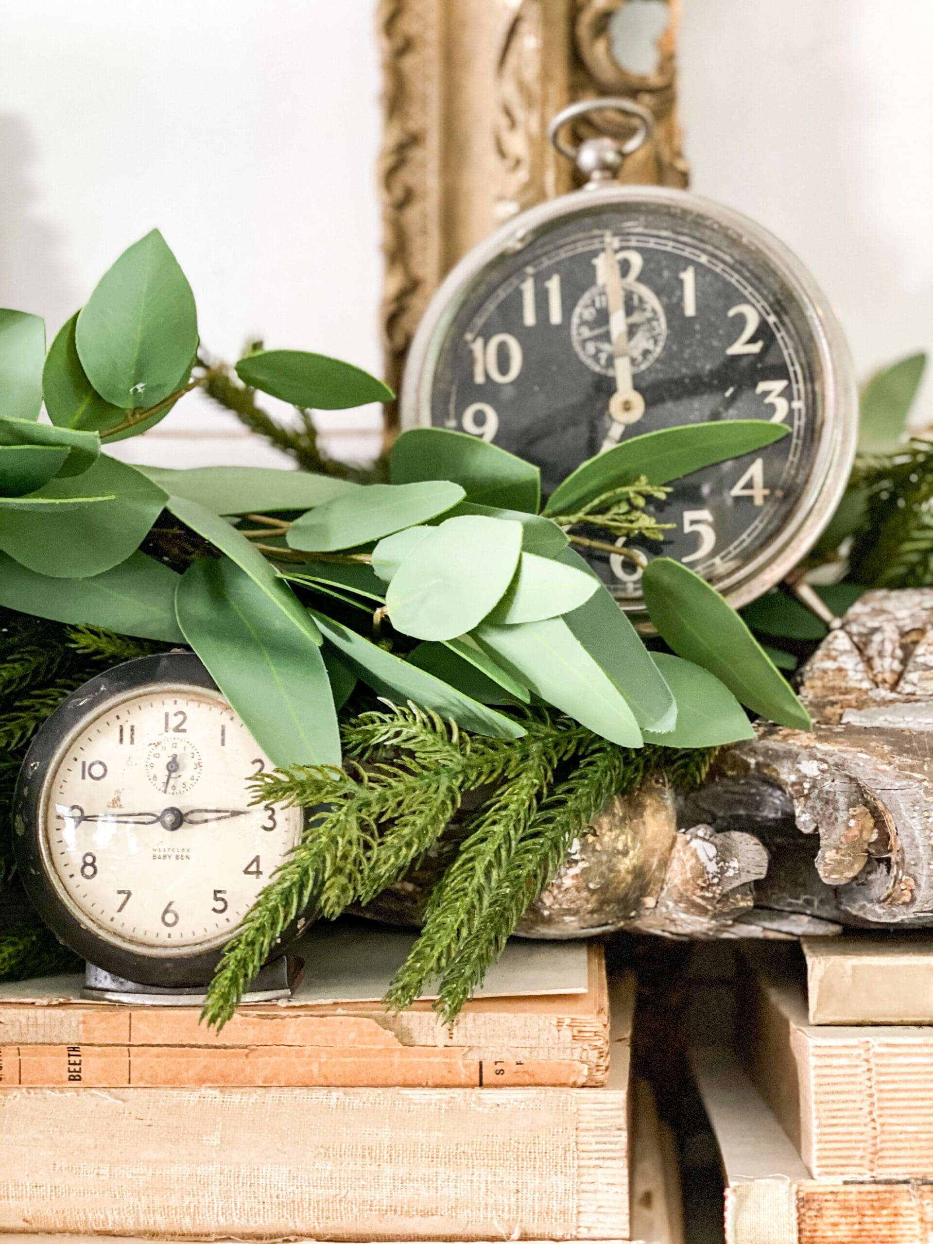 small vintage clocks placed around greenery in vignette