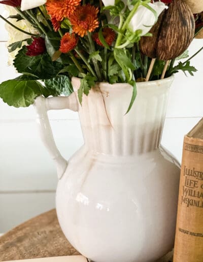 Closeup view of white ironstone pitcher holding fall florals