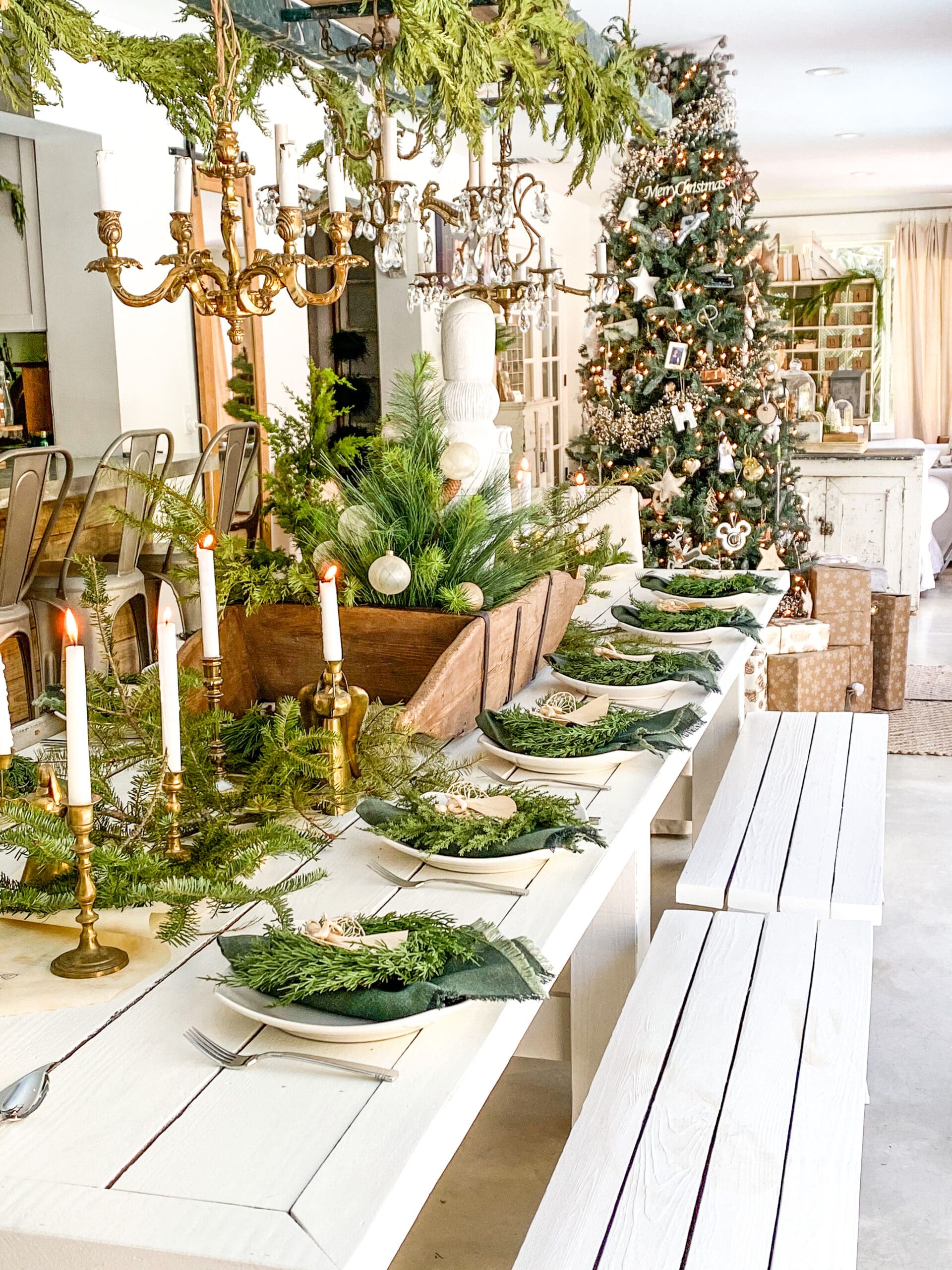 view of a Christmas table scape styled with golden candlesticks and mini wreaths