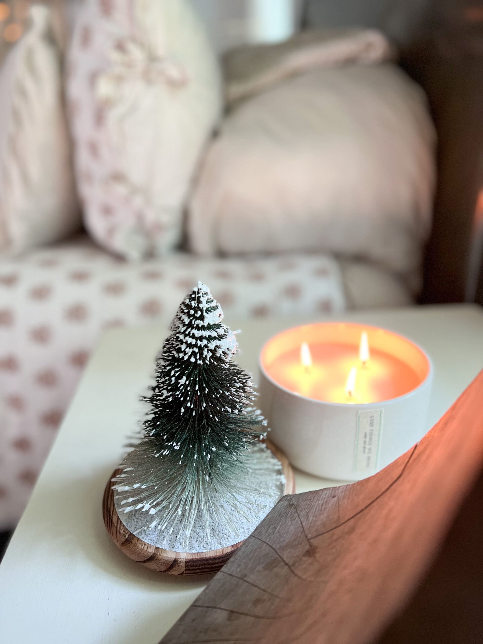 small winter candle with the lid beside it with a Christmas tree on it