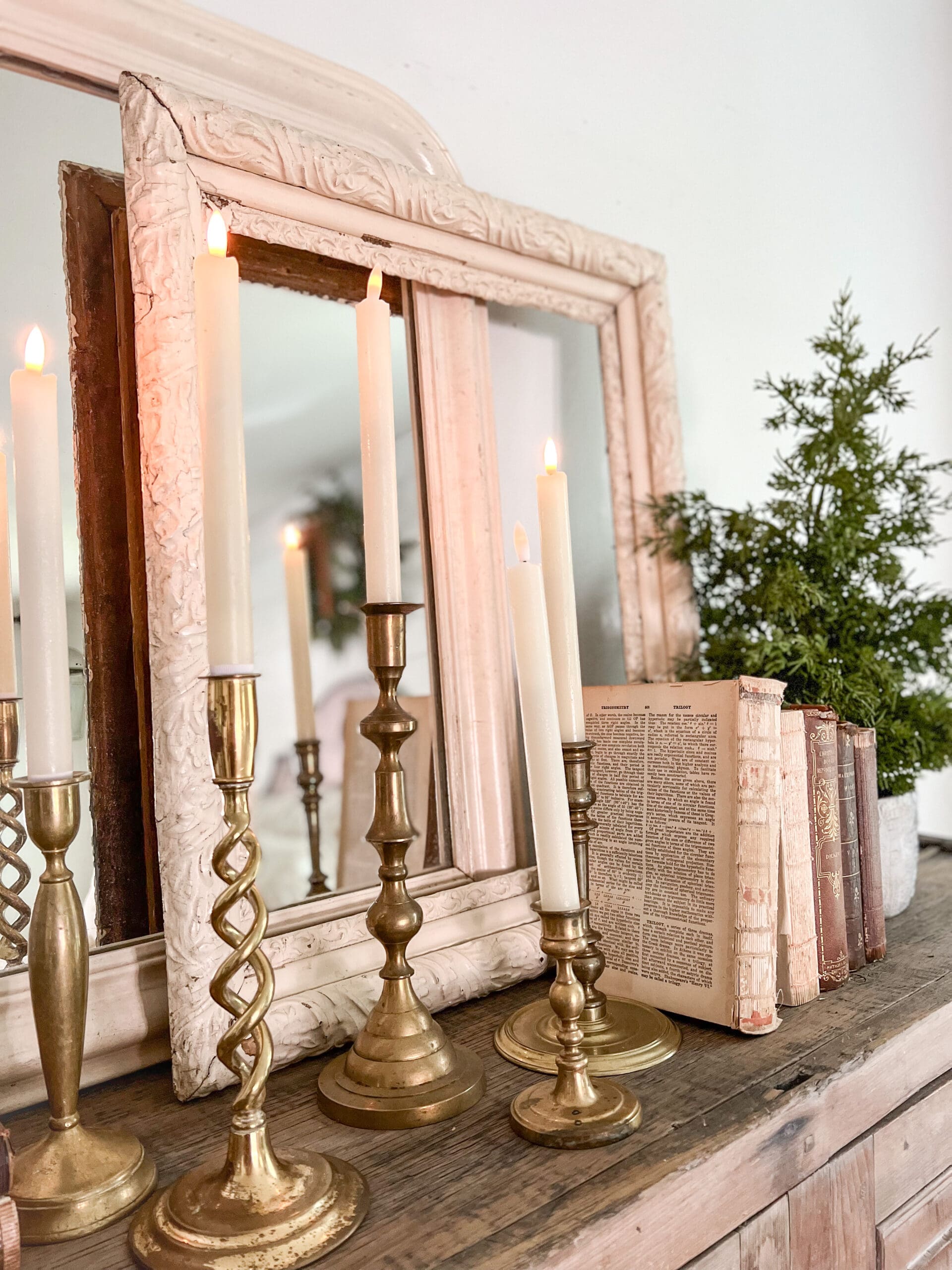 cabinet styled with brass candlesticks holding flameless candles