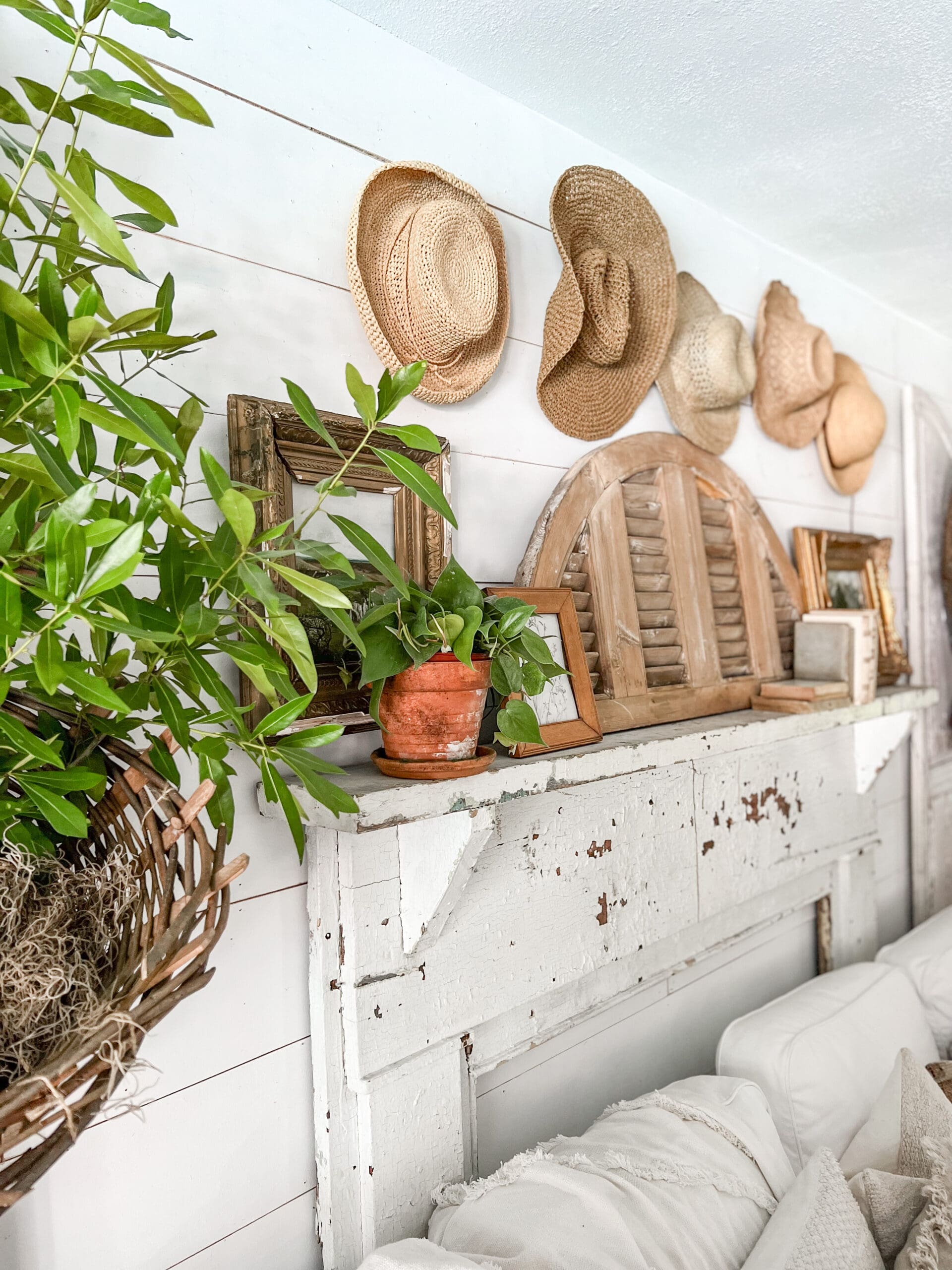 mantel with wicker baskets, and straw hats hanging behind it