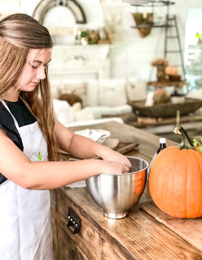 Payton mixing up dough in a bowl next to a pumpkin