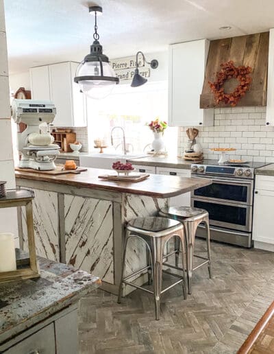 kitchen island with metal barstools and a large white vintage scale