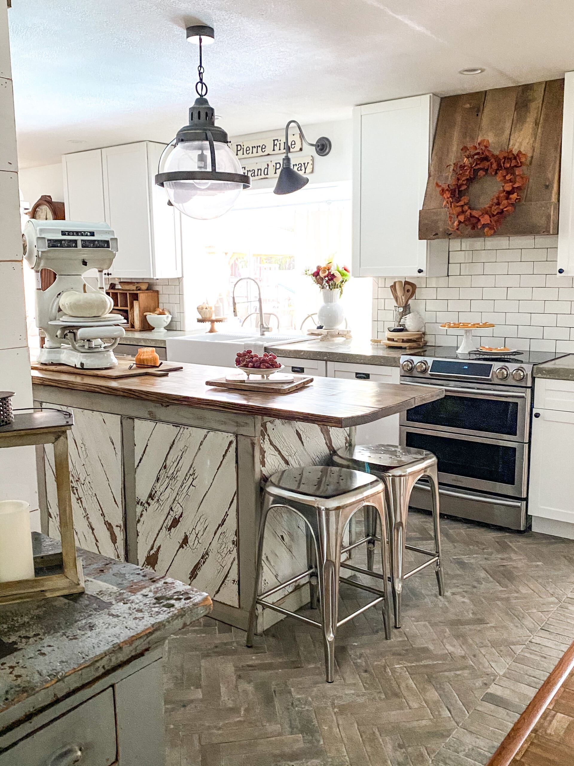 kitchen island with metal barstools and a large white vintage scale