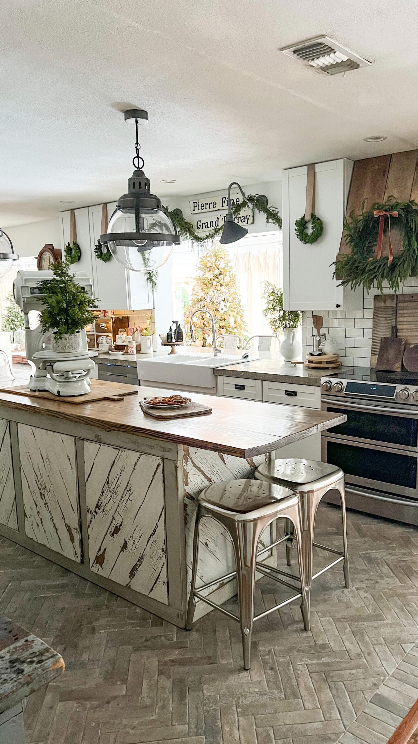 kitchen cabinets with small wreaths and a wooden kitchen hood with a large Christmas wreath