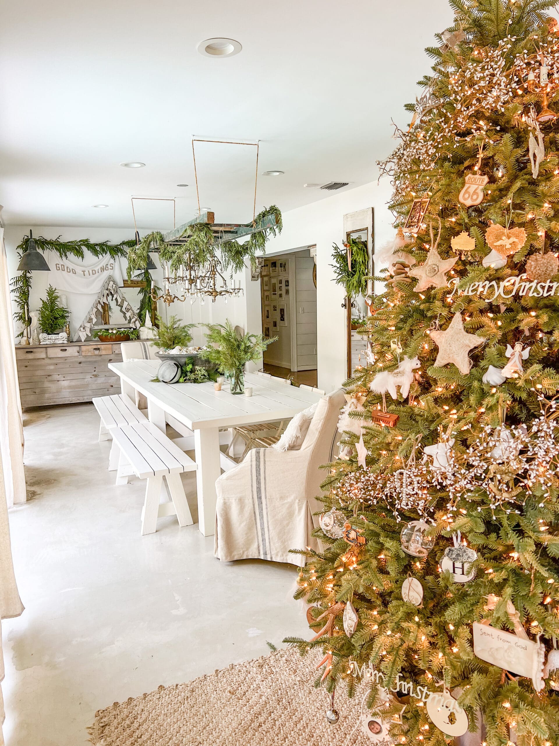 view of Christmas tree in front of a dining room with a ladder hanging above it
