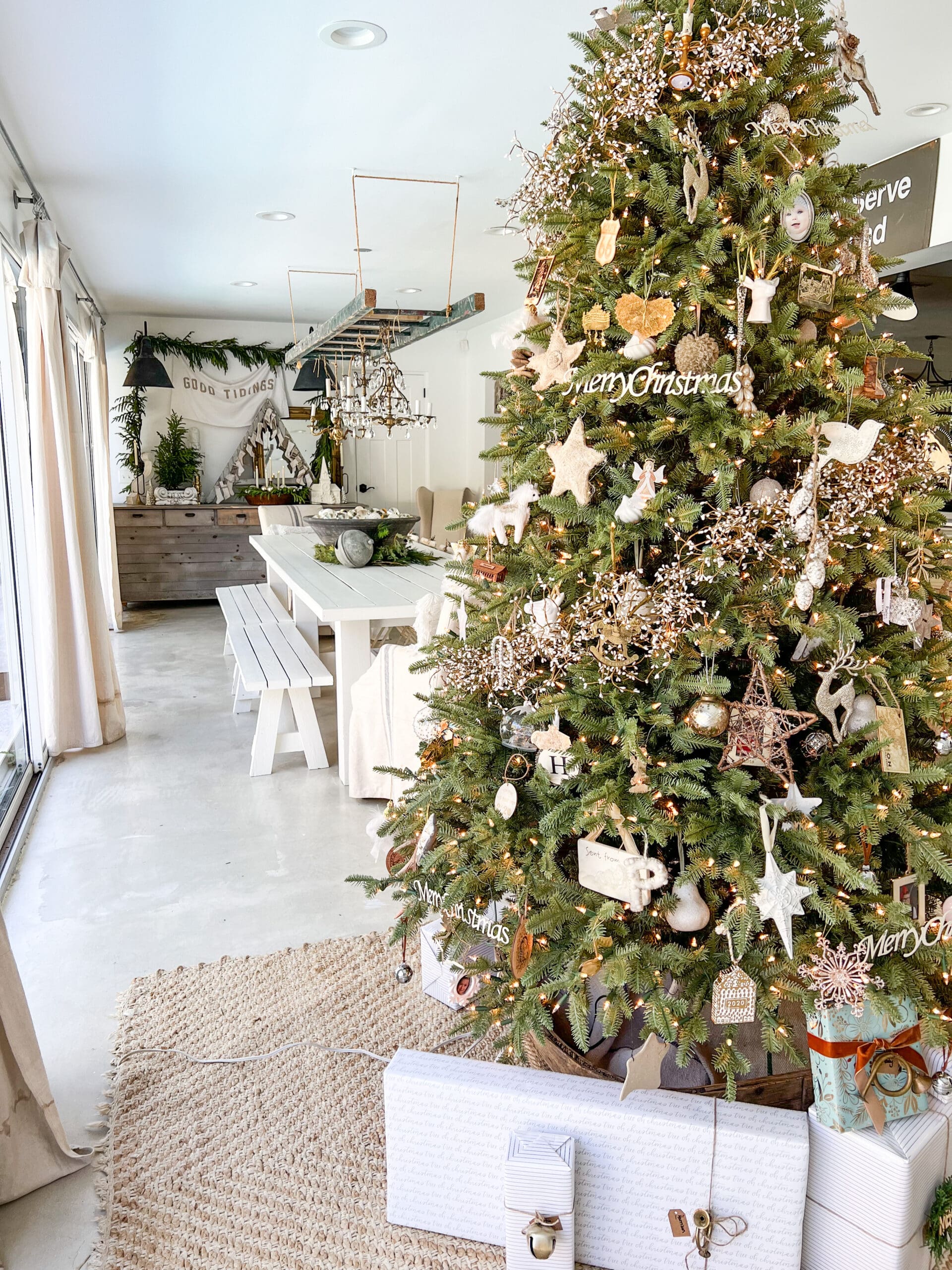 beautiful view of a Christmas tree and a dining room with real-touch Christmas greenery hanging from a  ladder