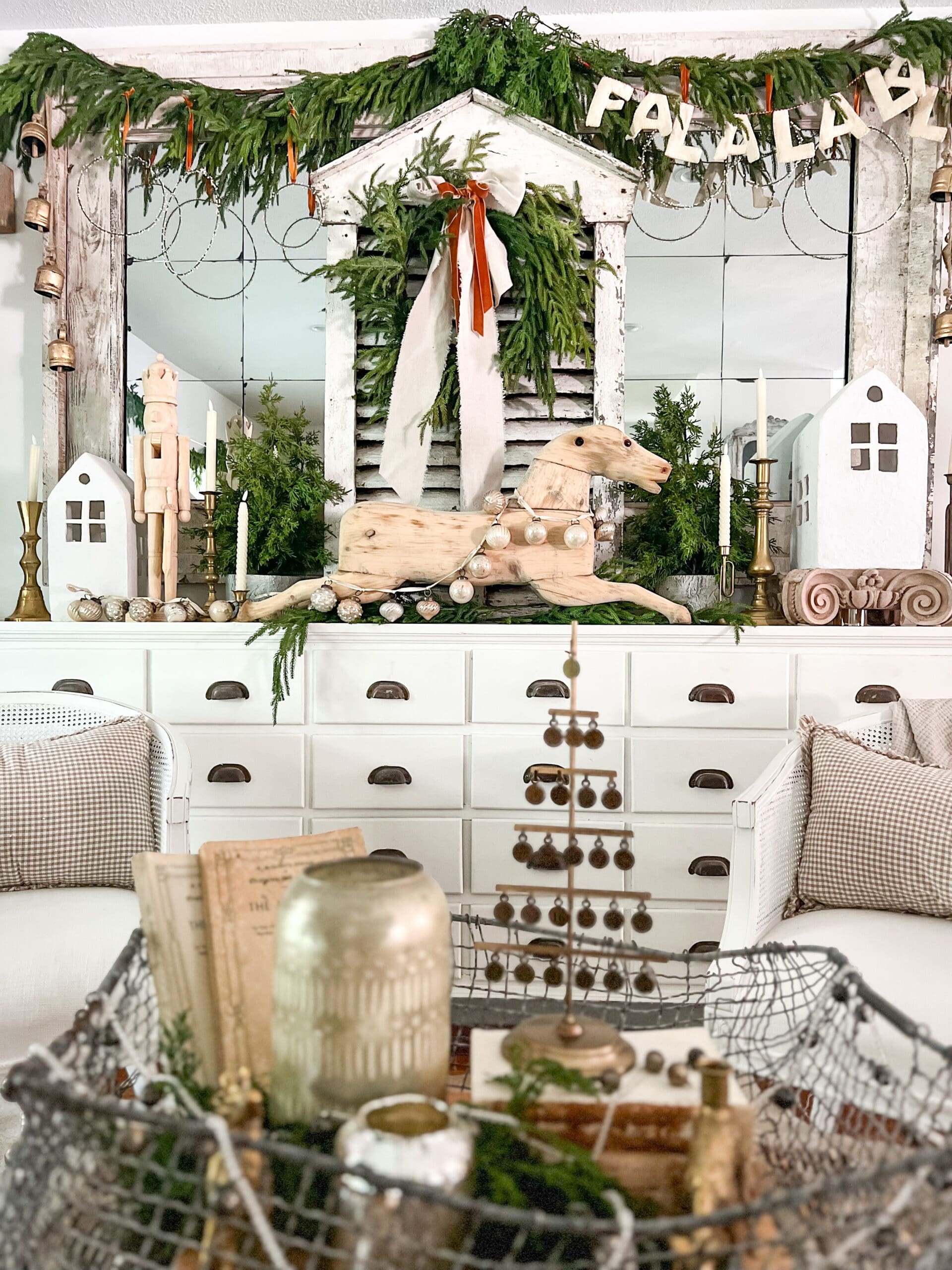 large white apothecary styled with greenery and a large wooden rocking horse