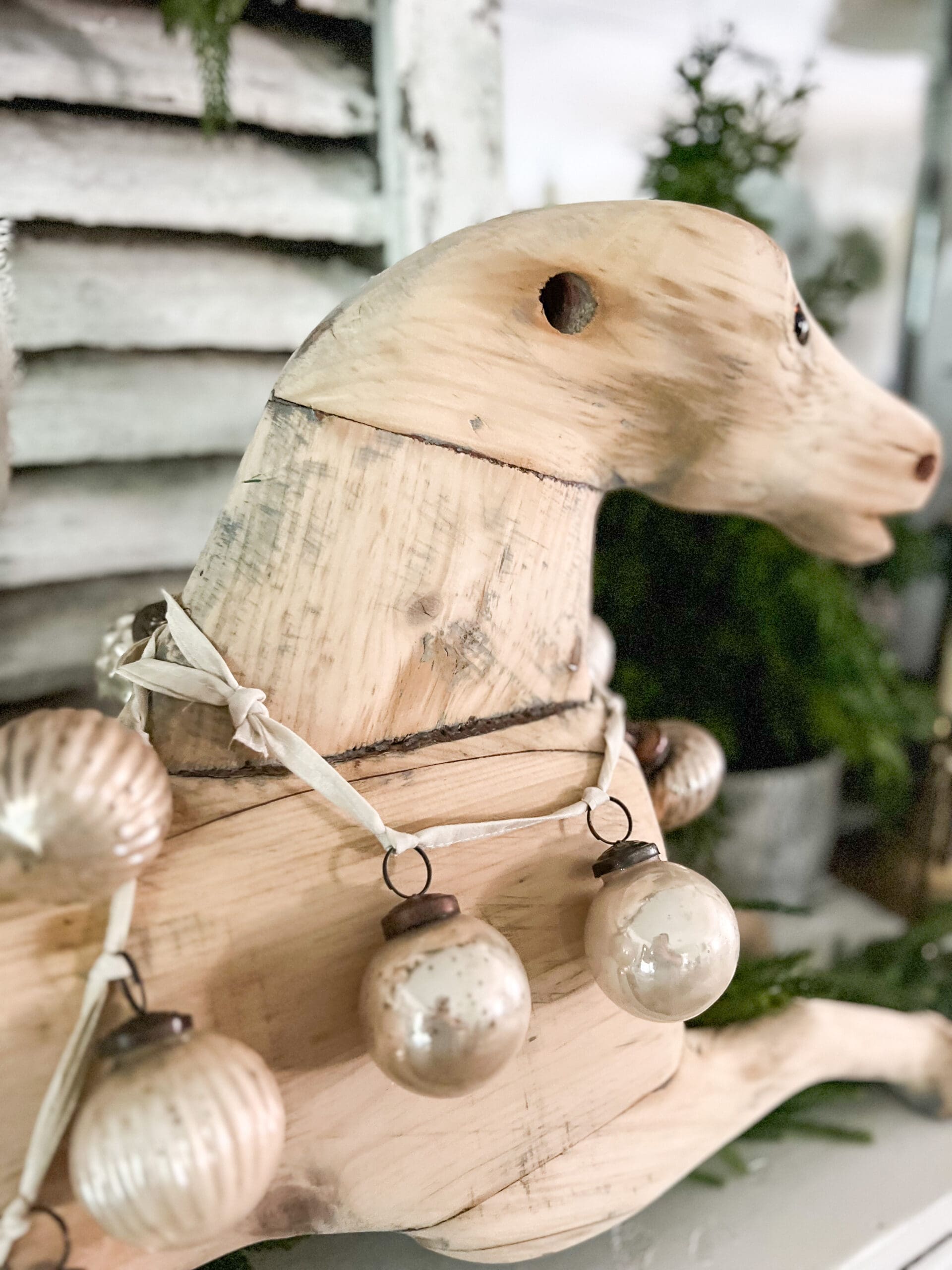 wooden rocking horse with ornament garland strung across the neck