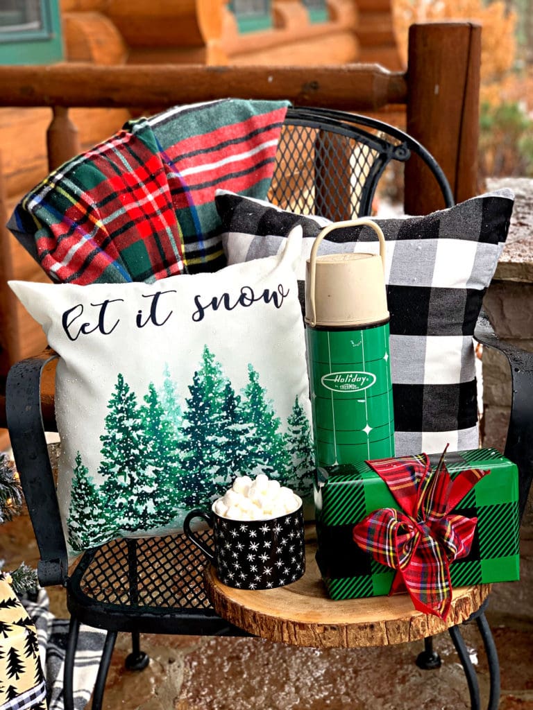 small black chair with a Christmas throw blanket and pillow
