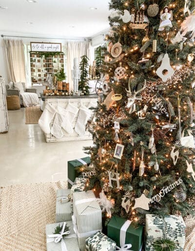 Neutrally decorated Christmas tree with wrapped presents in green & white wrapping paper underneath.