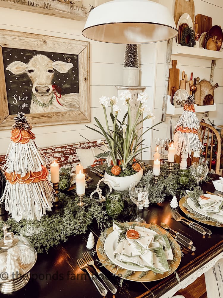 Christmas table scape with garland all over the table and styled with orange slices