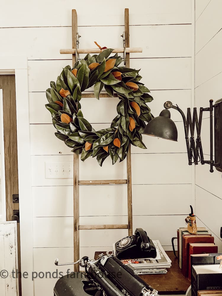 beautiful wreath with magnolia leaves hung on an antique ladder