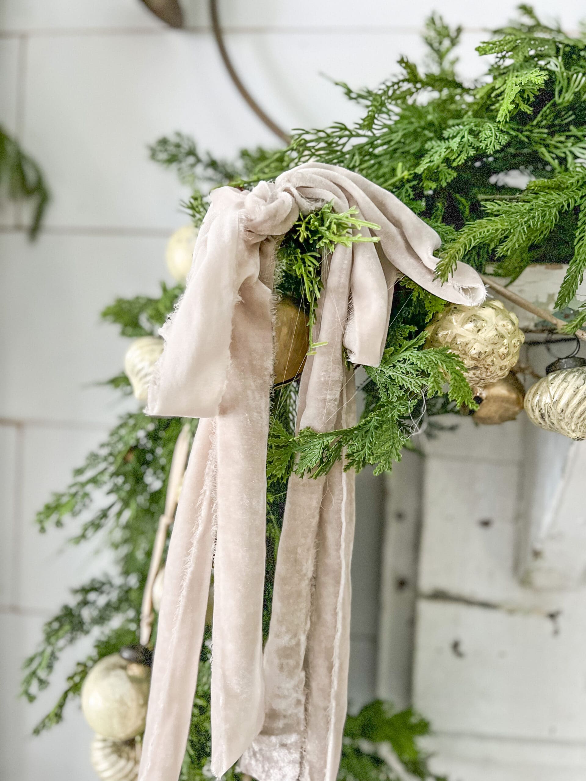 piece of vintage ribbon tied at the end of a garland of greenery