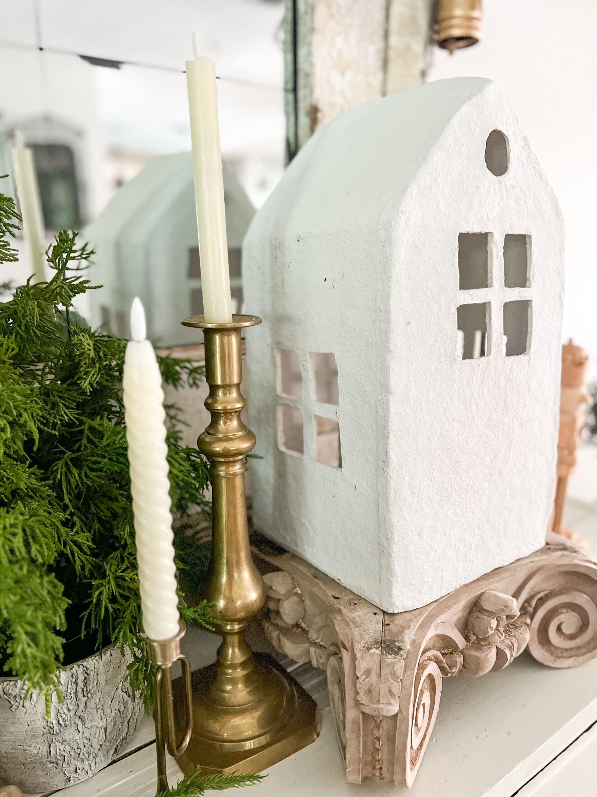 view of a small White House on a piece of wooden architectural salvage next to a golden candlestick