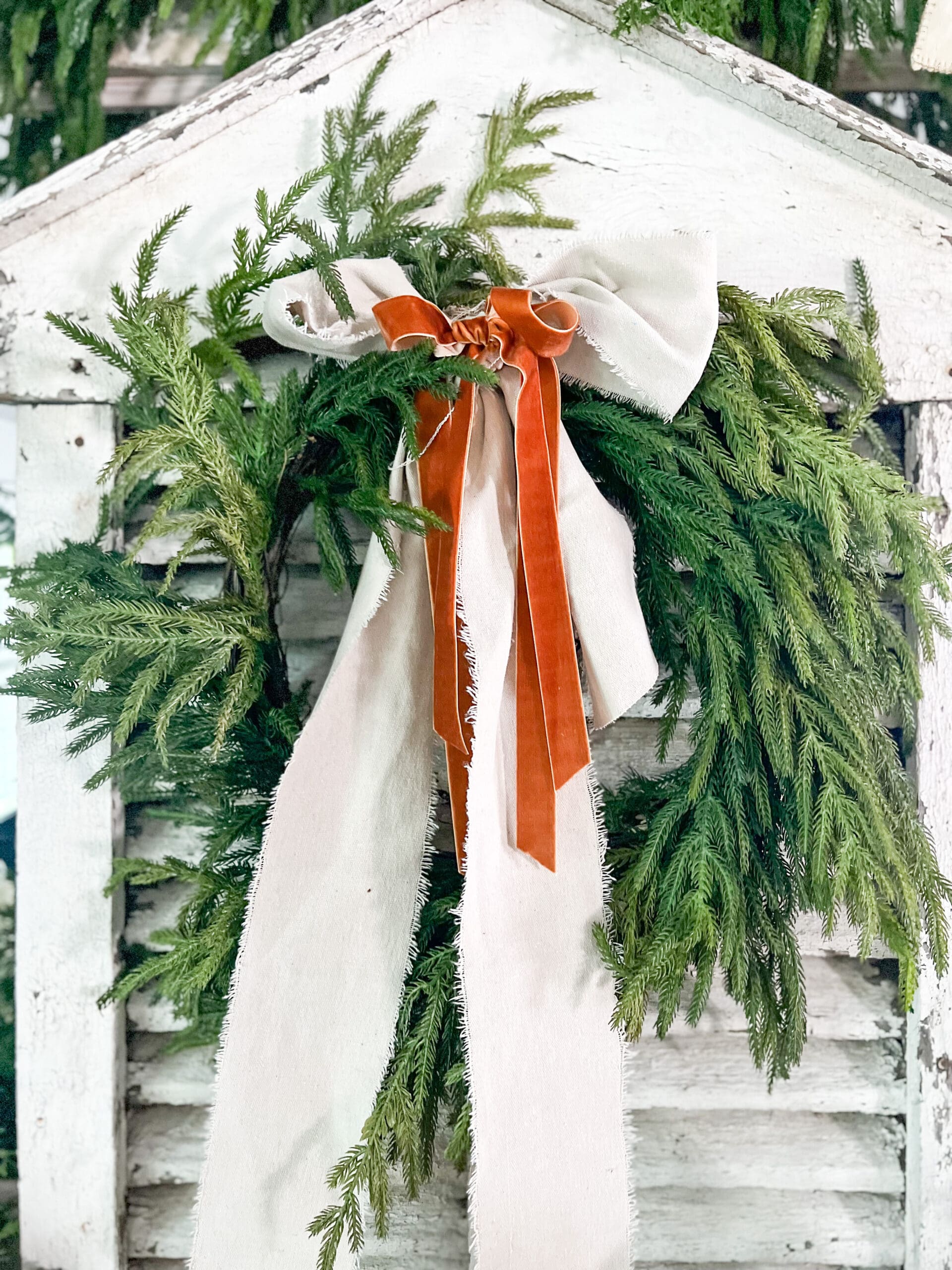 Christmas wreath with velvet ribbon tied on a large white window