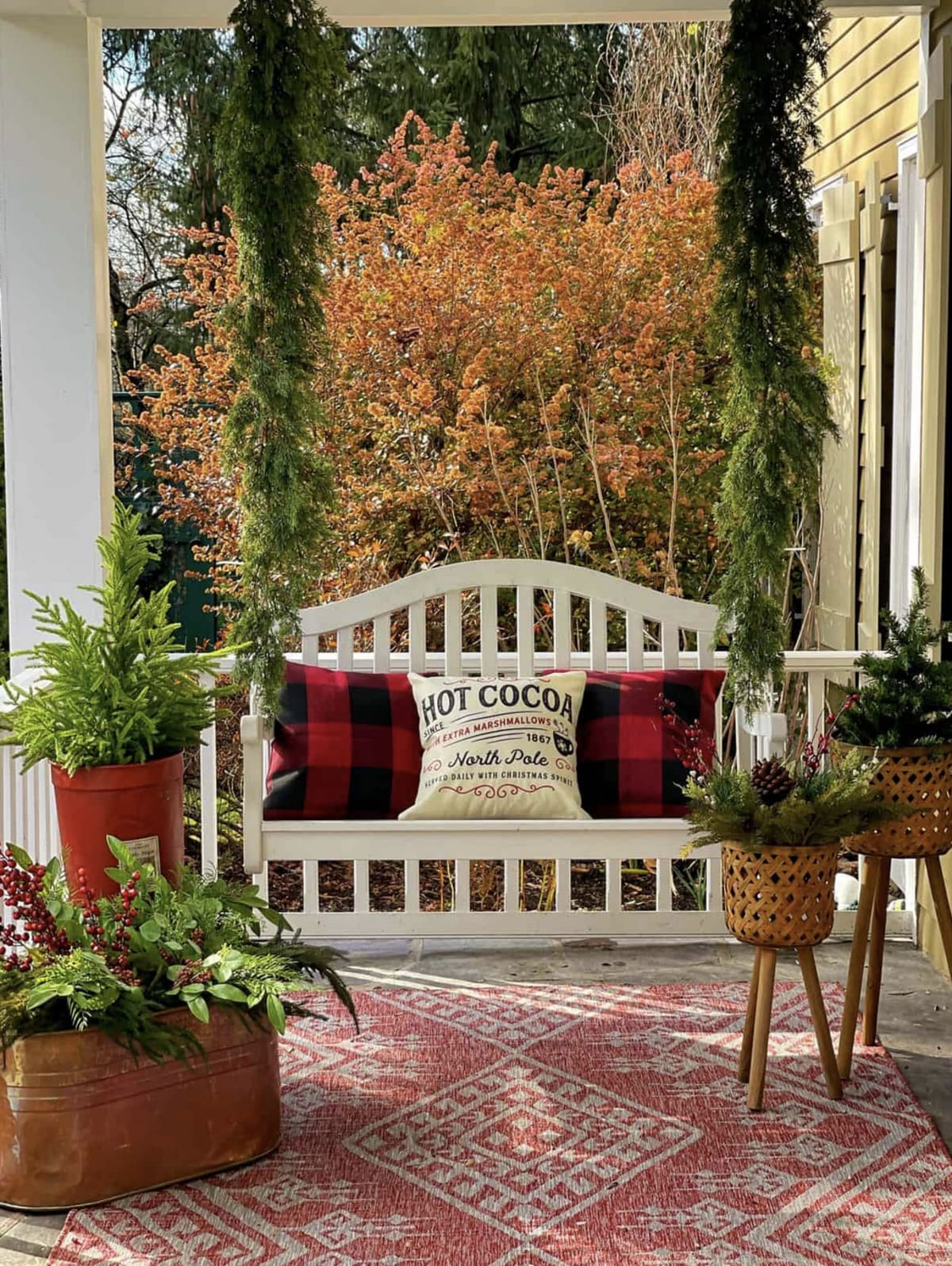 cozy white porch swing styled with Christmas pillows 