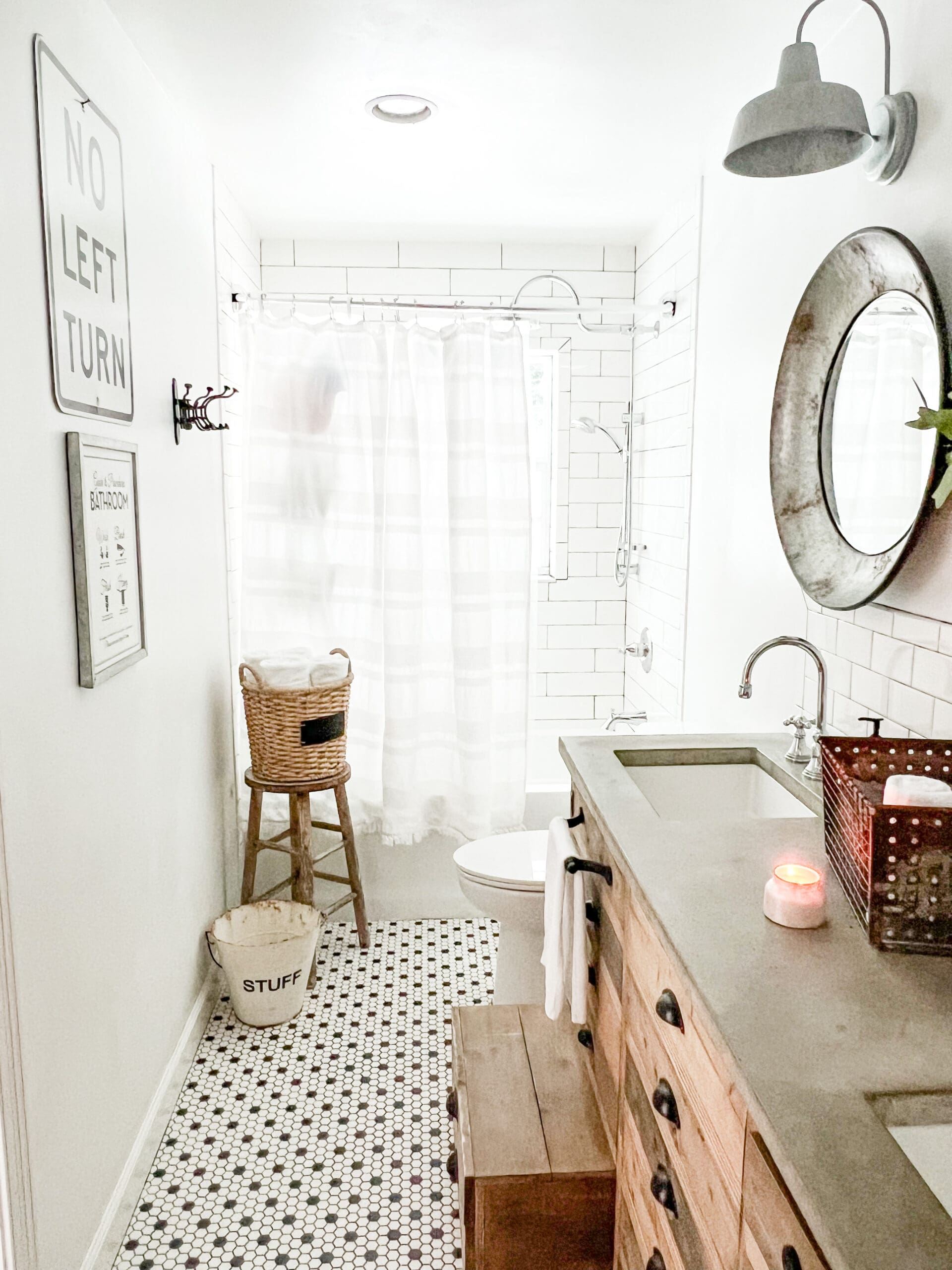 view of a beautiful neutral bathroom with a wood vanity and concrete countertop and small stool in the corner holding a basket of towels
