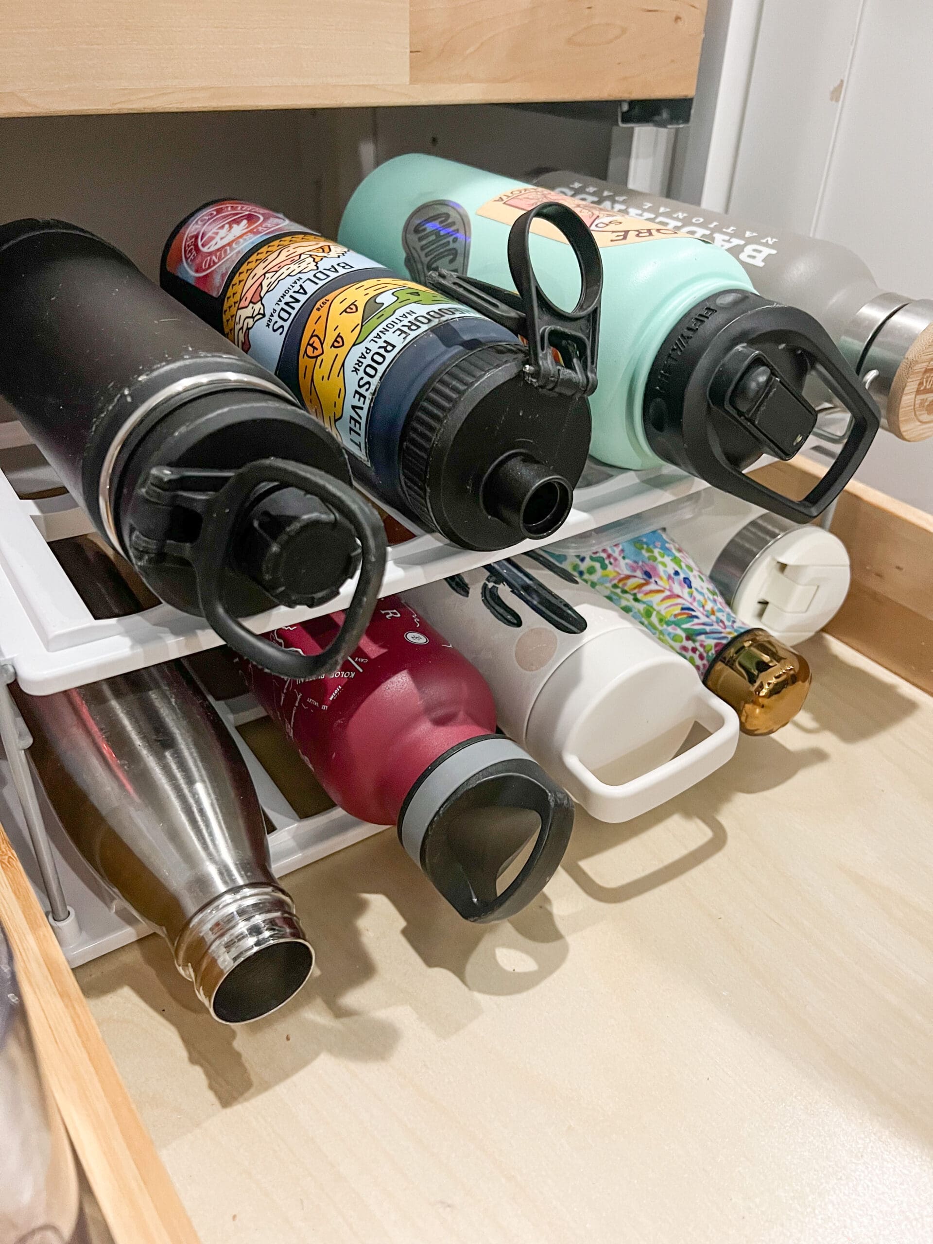 image of water bottles on a white metal organizer shelf
