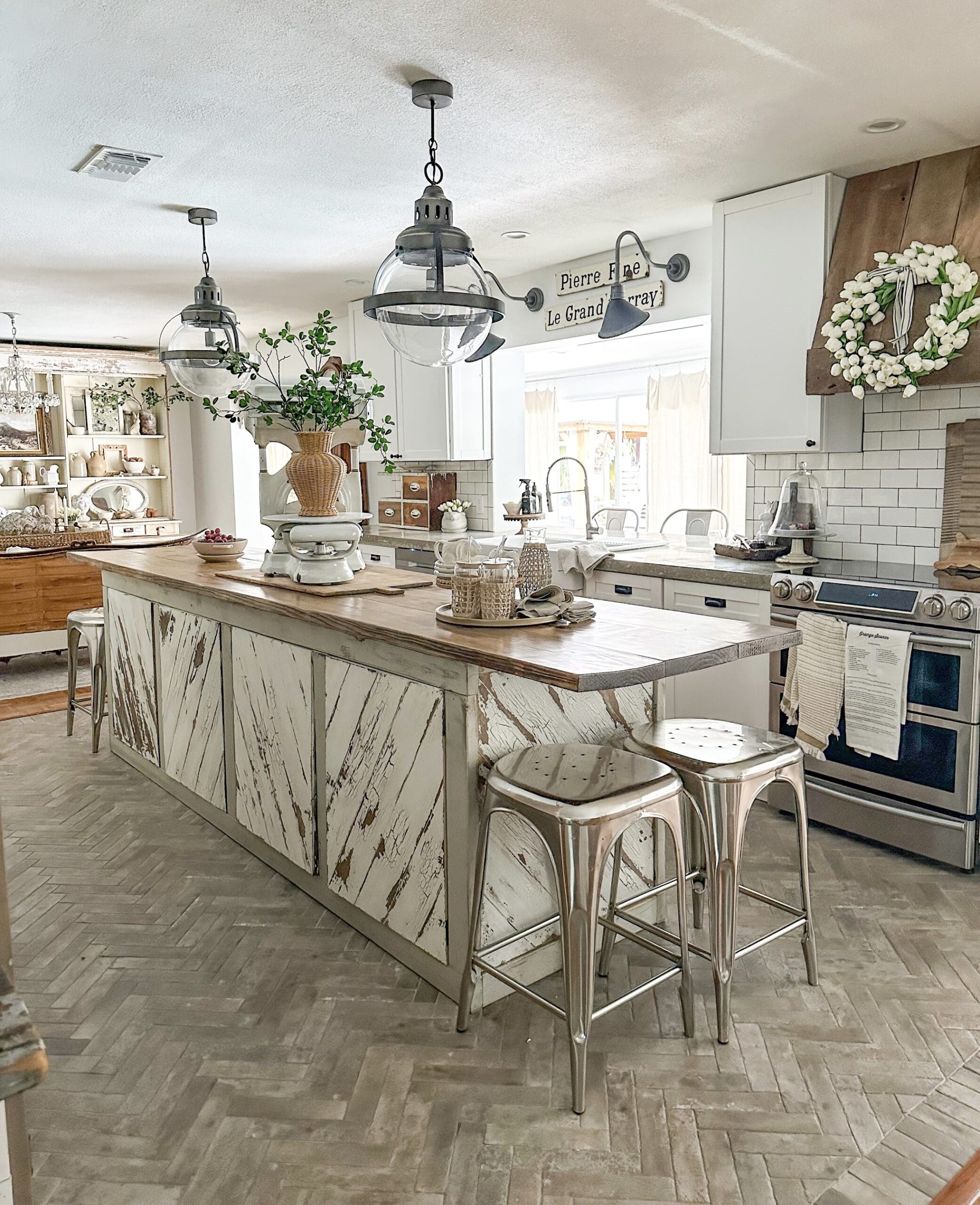 beautiful neutral kitchen with a wooden stove hood and a long gorgeous island 