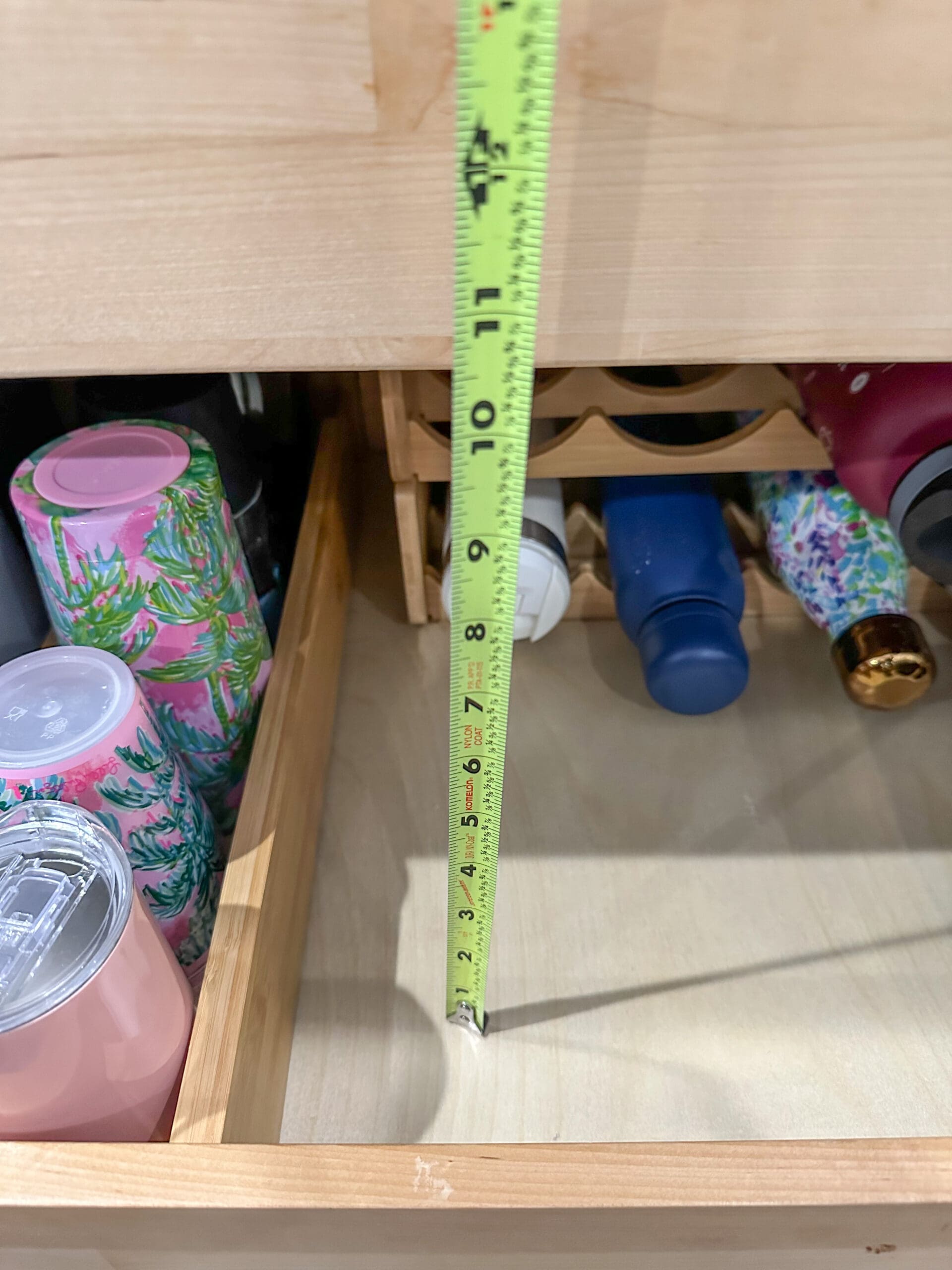 a tape measure being used to measure the height of the shelf