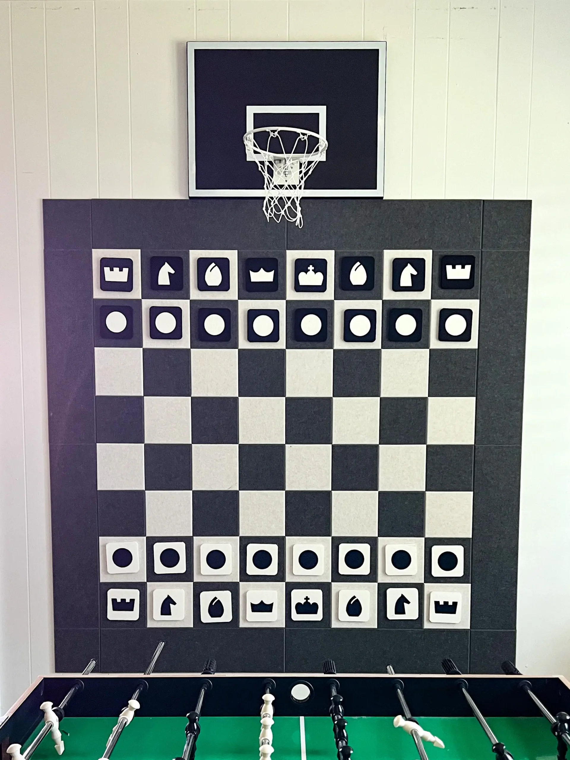 large felt black and white chess board on a white wall in the playroom