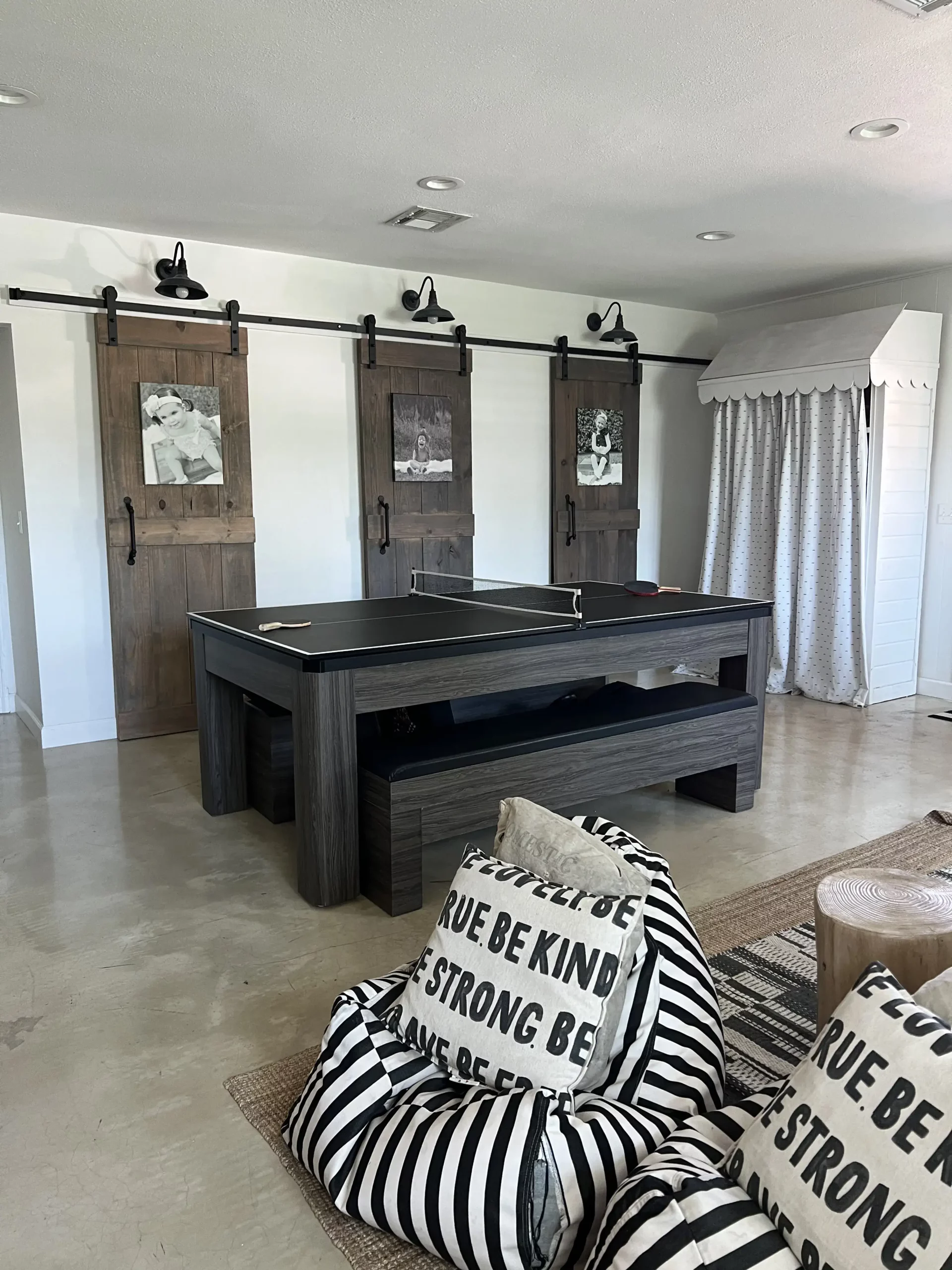 view of a black and white ping pong table in a neutral game room