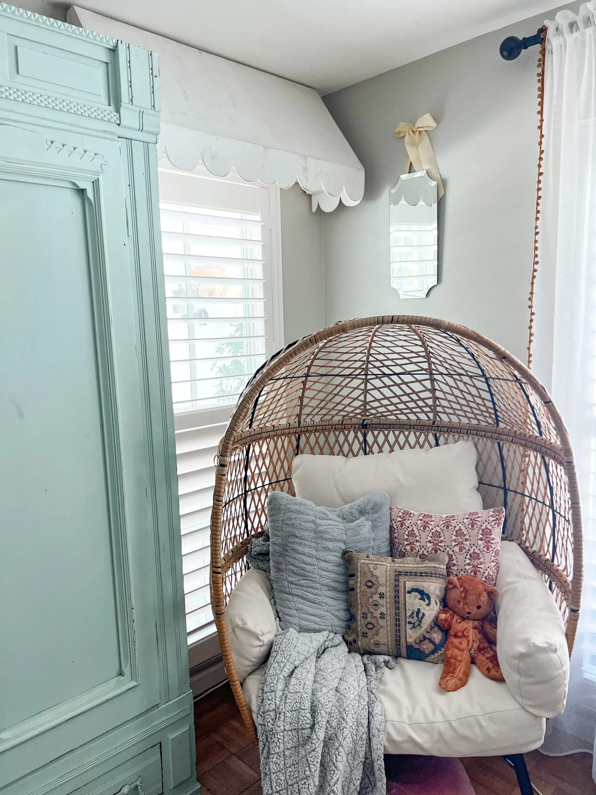 white wooden scalloped awning over a window with plantation shutters in the girls' room