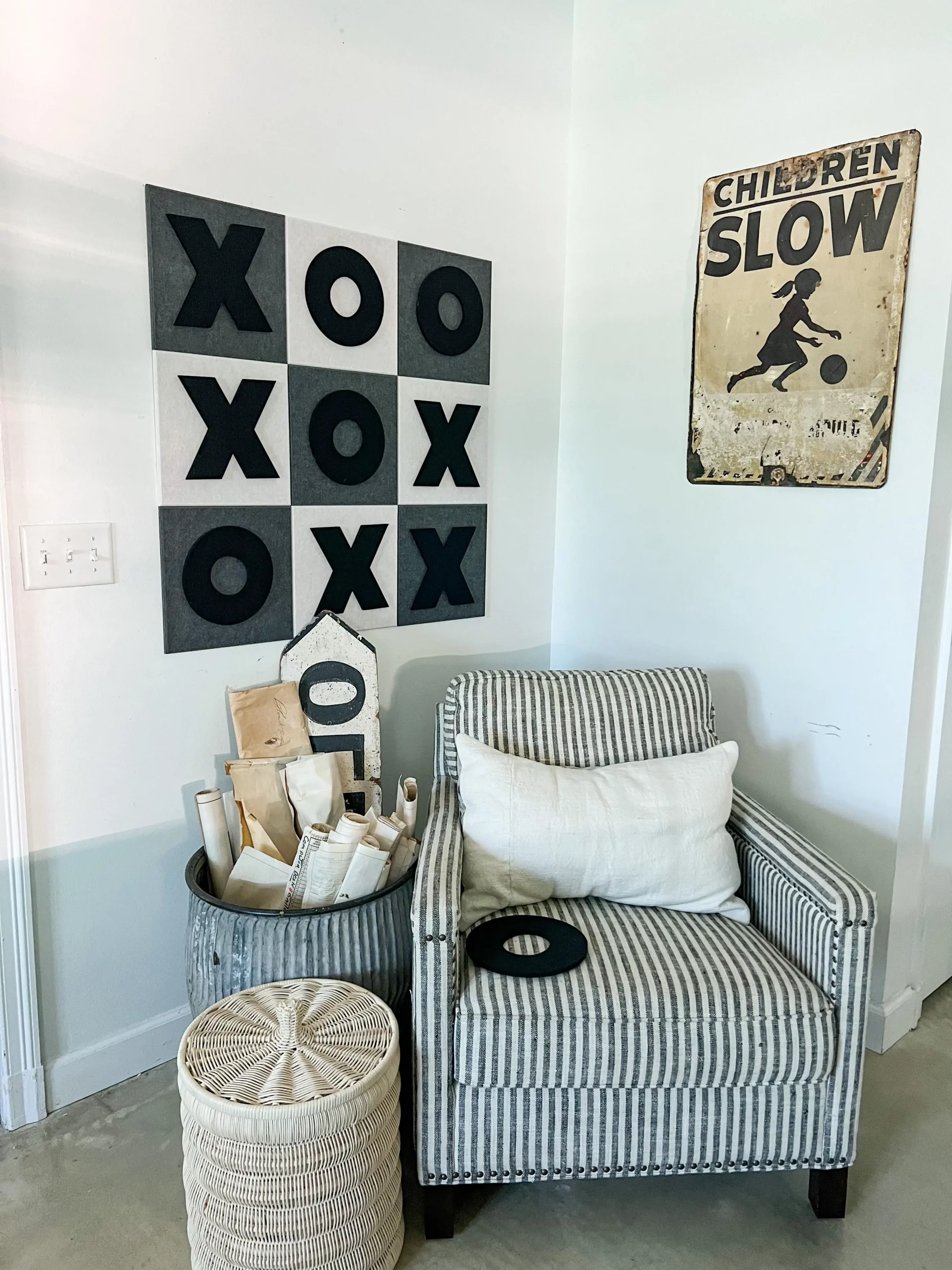 felt tic tac toe board behind a cozy striped chair in the game room