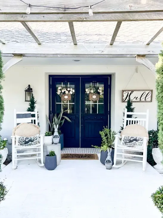 wide angles of a beautiful spring porch with rocking chairs and easter pillows, and planters holding various flowers and plants