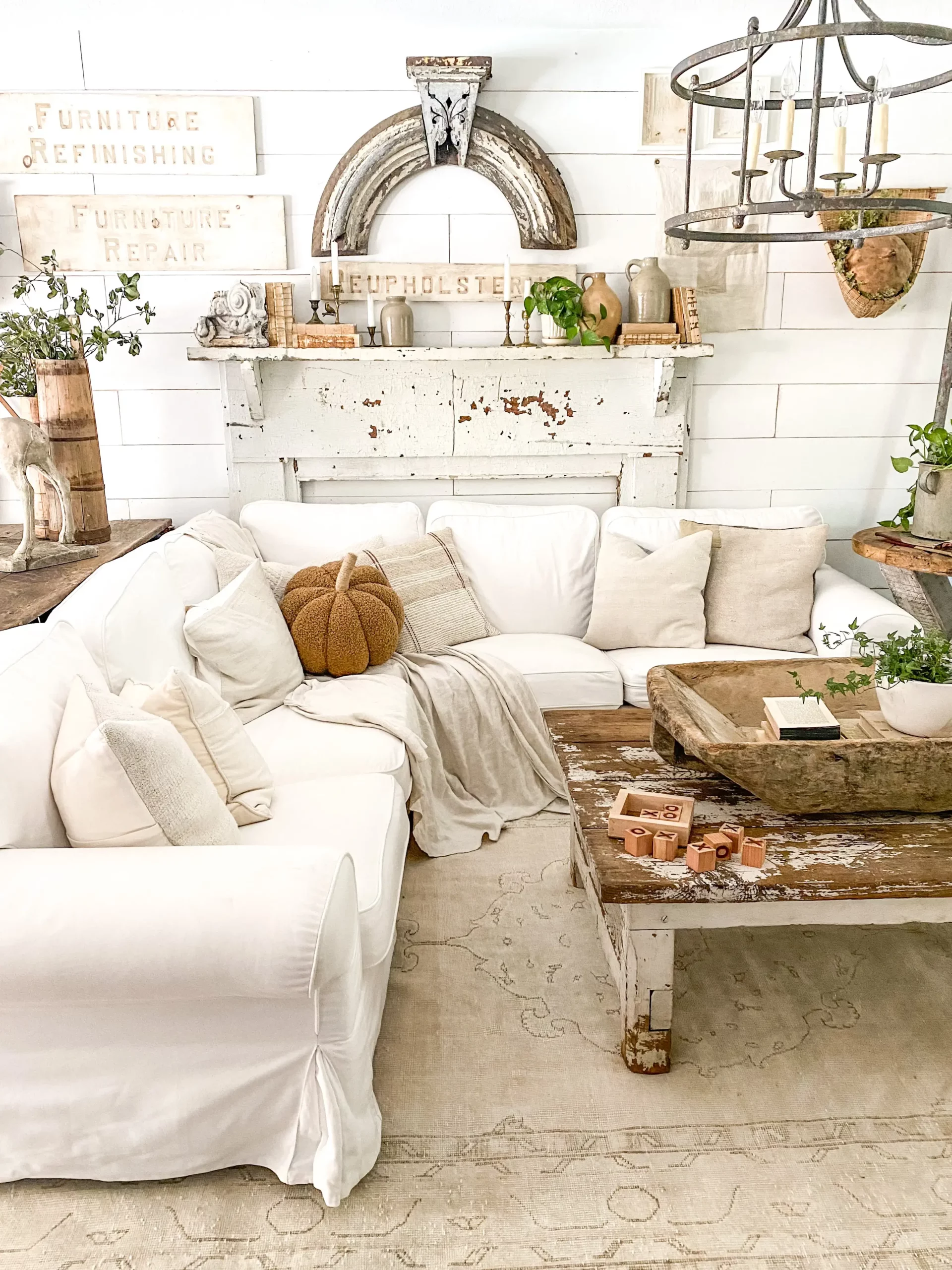 large chippy white architectural salvage hanging above a white mantel among various spring decor elements
