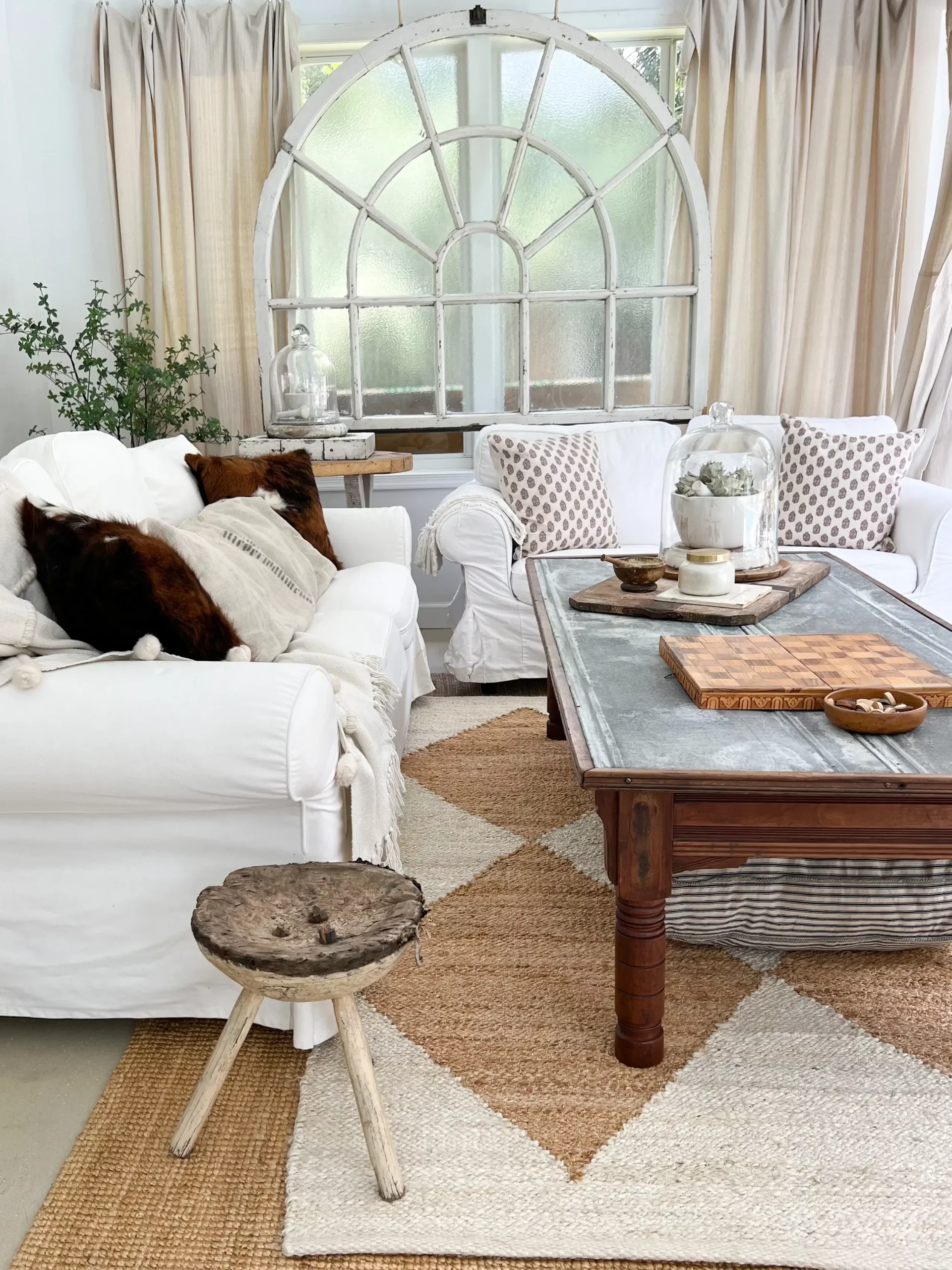 back living room area with a round side table holding a plant in between the two sofas