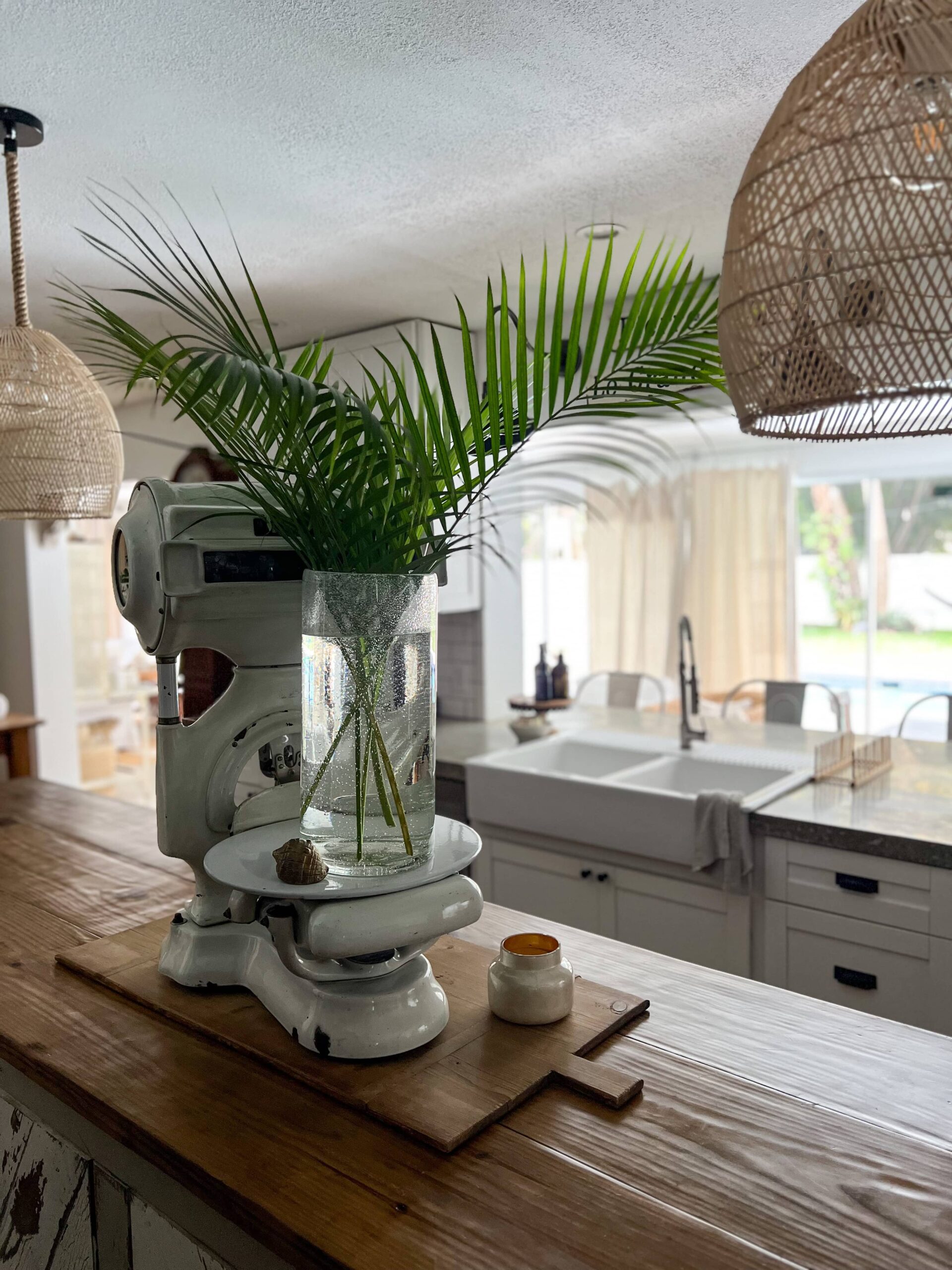vase with palm fronds on a white vintage scale on an island in a neutral coastal kitchen