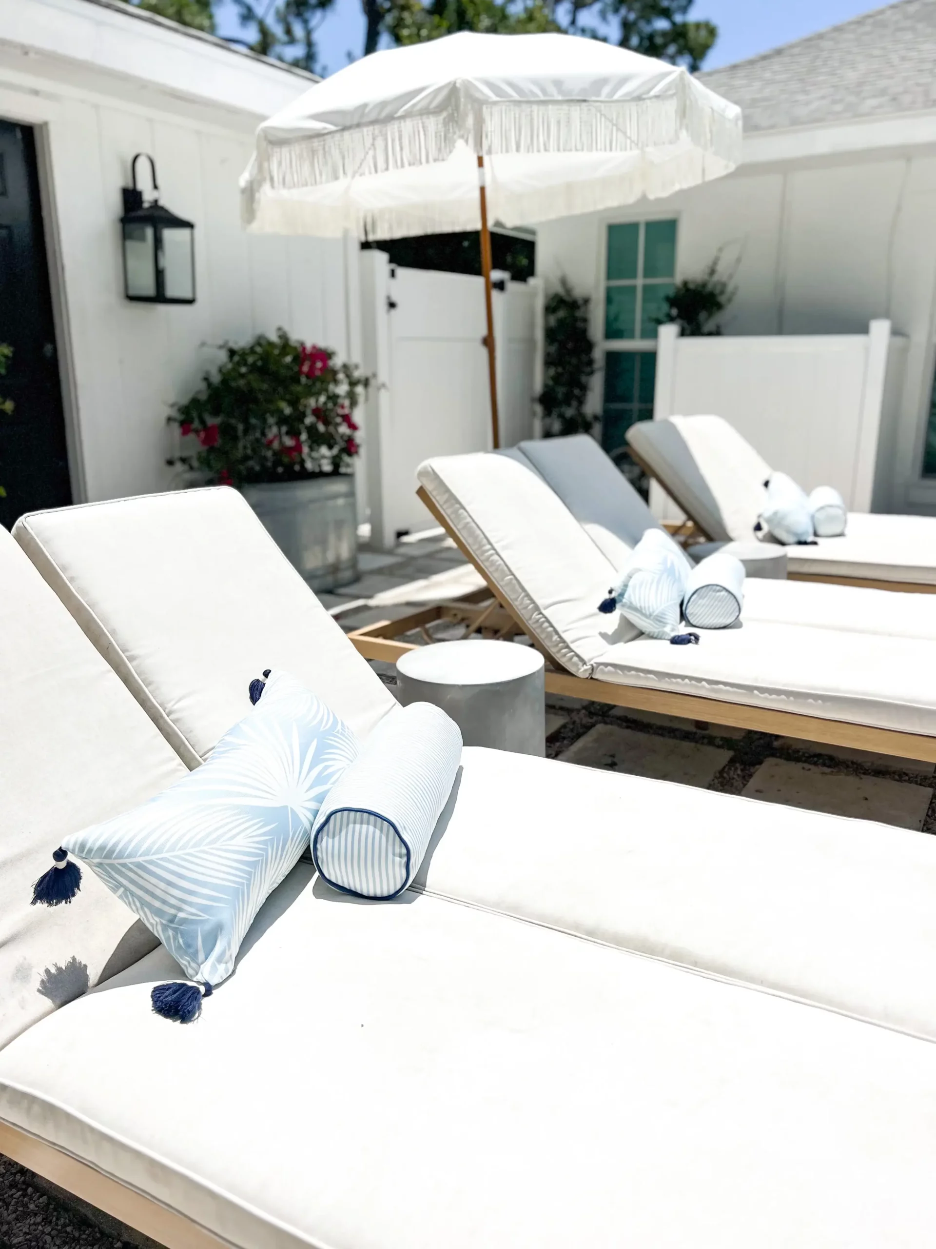 gorgeous white chaise loungers with blue and white outdoor pillows